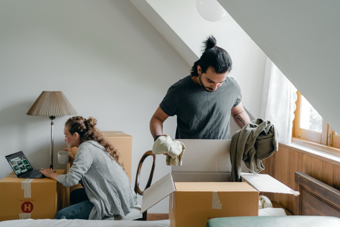 Paar packt Umzugskartons in einem Dachzimmer